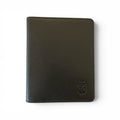 A black genuine textured leather timebook cover with a debossed shield logo in the bottom right corner, shown on a plain white background.